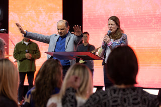 J.John and Killy John pray for people whilst on stage at a church