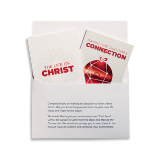 An open Christmas Response Pack with its contents displayed, including The Life of Christ, Making the Christmas Connection by J.John, and a response envelope.